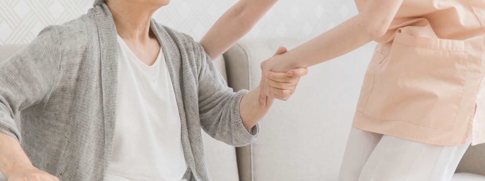 看護師がご利用者様の手にそっと寄り添う様子